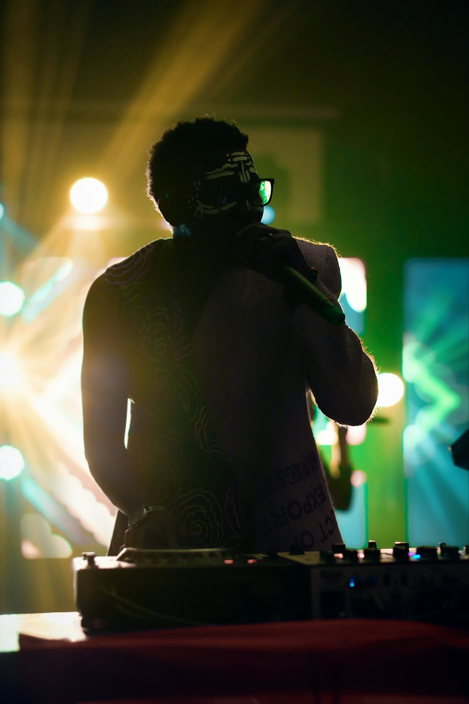 DJ aux platines sous des jeux de lumière colorés