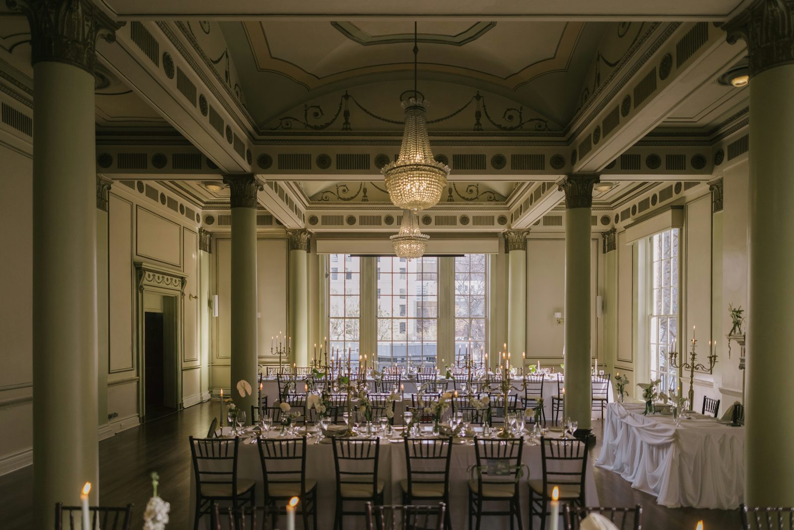 Salle de gala habillée de lustres en cristal et de tables dressées
